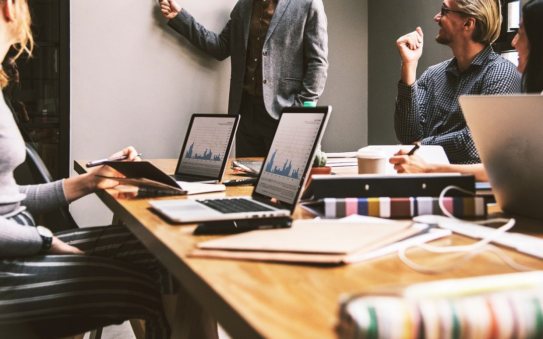 Menschen an einem Tisch mit Laptop
